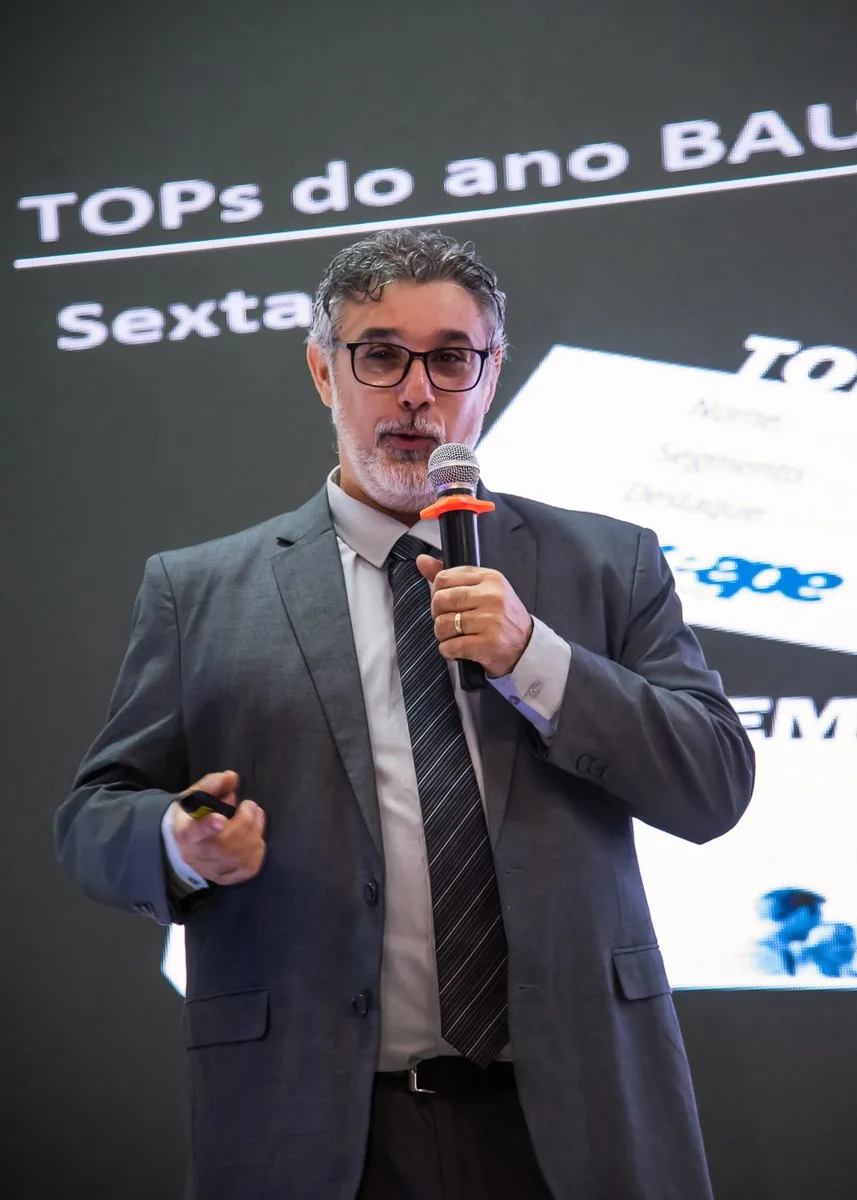 Palestrante com microfone durante a apresentação dos TOPs do ano no Meepe
